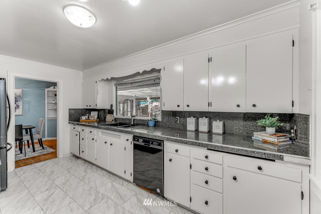 301 North Cabot Road Everett, WA 98203 - Photo 11 of 36 a kitchen with granite countertop white cabinets and white appliances