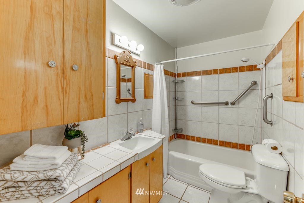 301 North Cabot Road Everett, WA 98203 - Photo 21 of 36 a bathroom with a granite countertop sink a toilet and shower