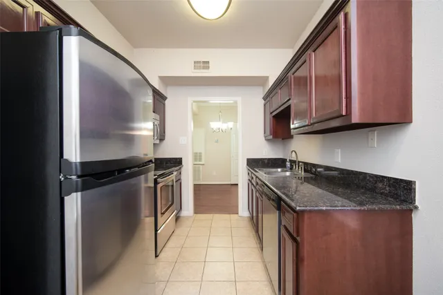 a kitchen with a refrigerator sink and cabinets