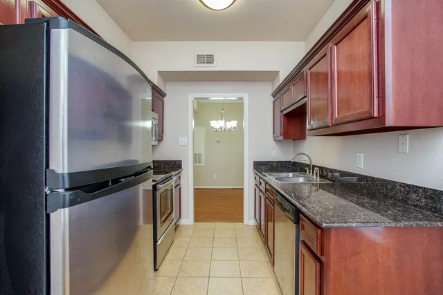 a kitchen with granite countertop a sink and a stove top oven