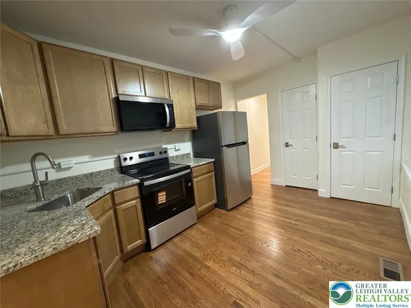 a kitchen with granite countertop a refrigerator and a sink