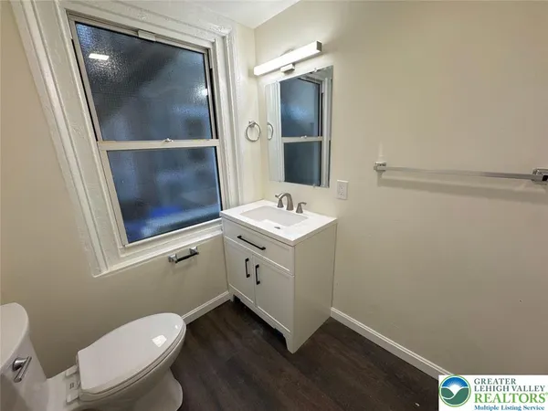 a bathroom with a sink mirror vanity and toilet
