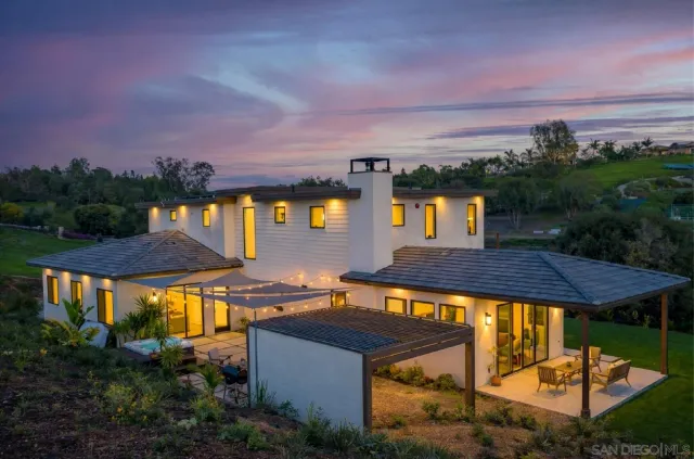 a view of a patio with couches table and chairs and potted plants