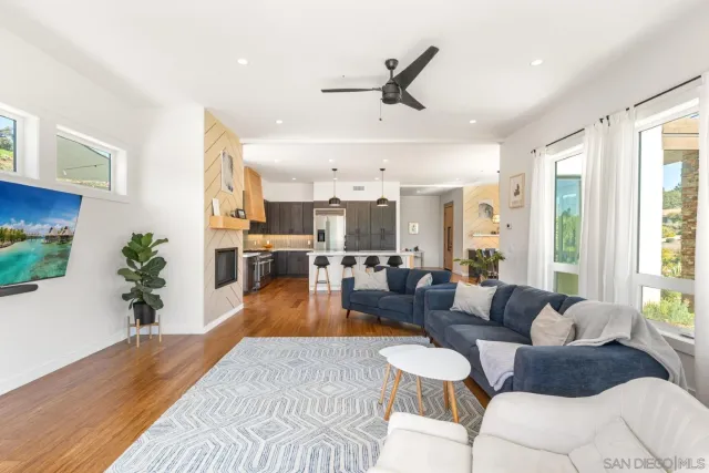 a large kitchen with granite countertop a stove a sink a refrigerator and a wooden floor