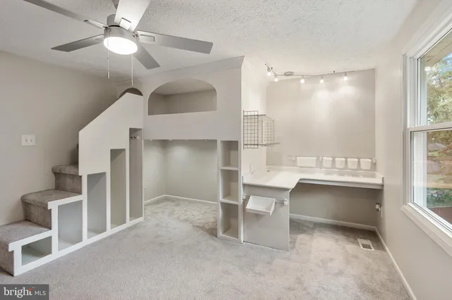 a view of a hallway with workspace and a window