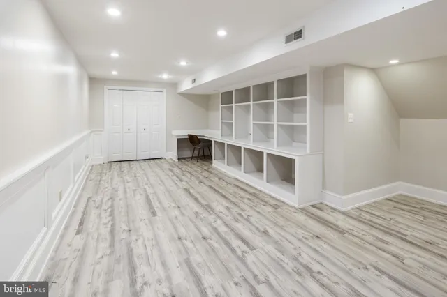 a view of empty room with wooden floor and windows