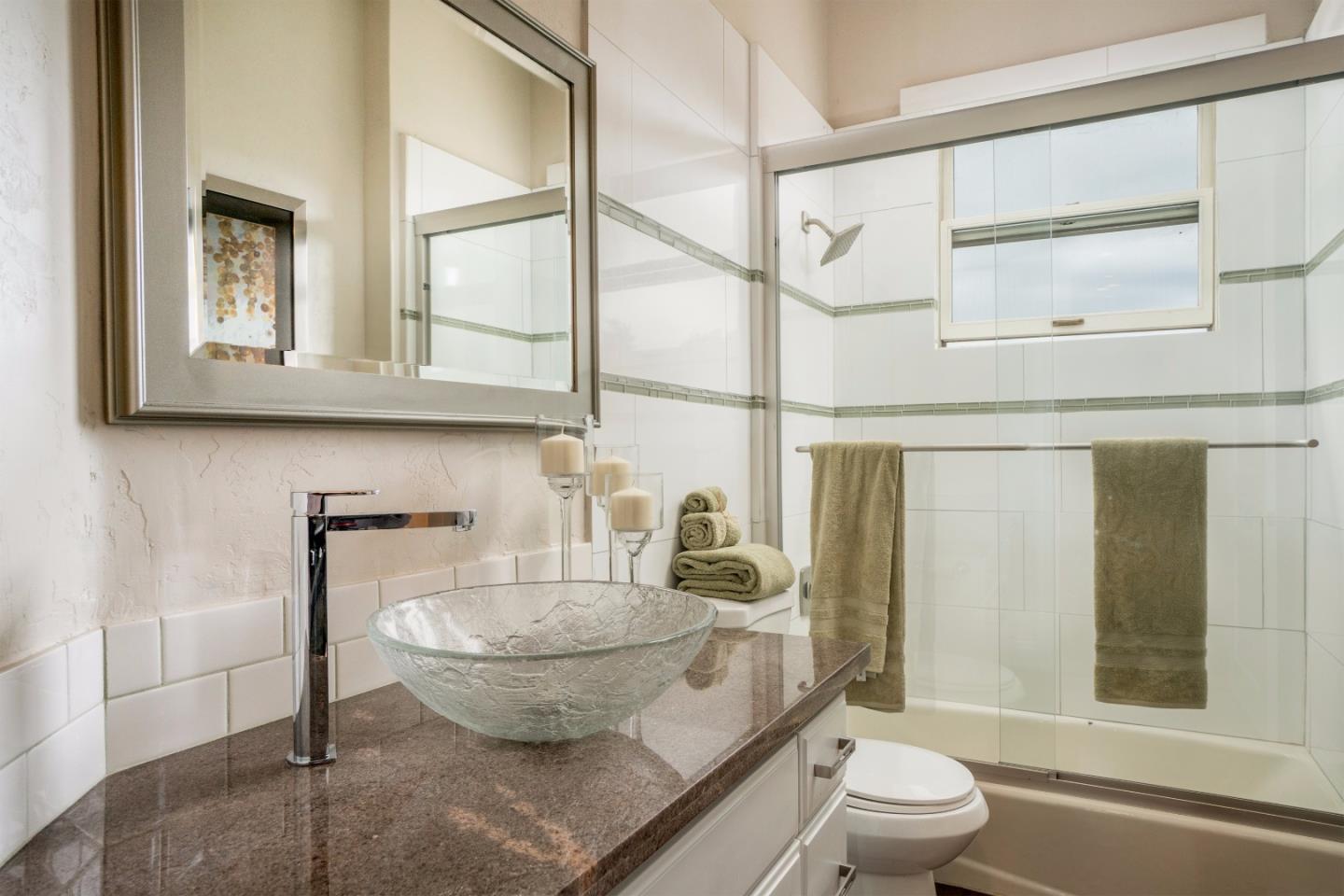 9945 Eddy Road Carmel, CA 93923 - Photo 22 of 31 a bathroom with a granite countertop sink mirror vanity and toilet