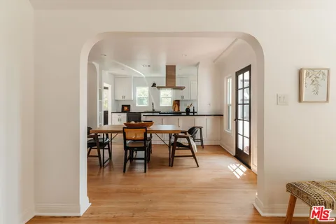 a kitchen with stainless steel appliances kitchen island a table and chairs