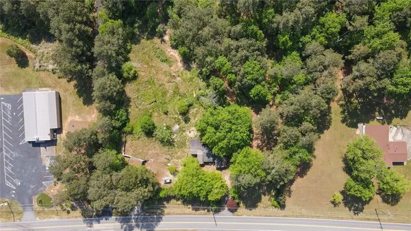 an aerial view of residential house with outdoor space and trees all around