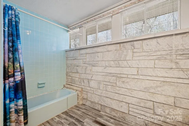 a bathroom with a bathtub and shower