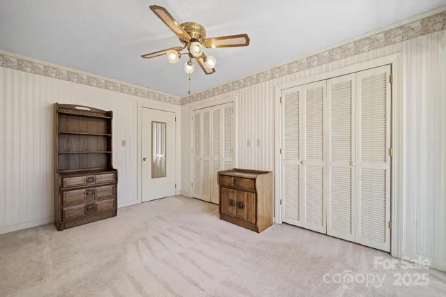 an empty room with closet and ceiling fan