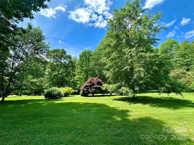 a view of green field of grass and trees