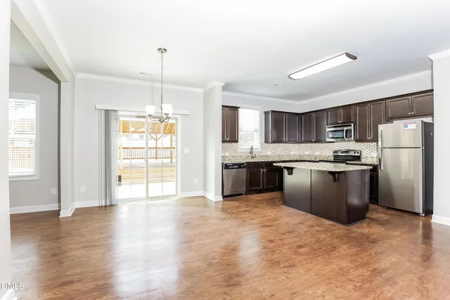 a kitchen with stainless steel appliances granite countertop a refrigerator a sink dishwasher a stove with white cabinets