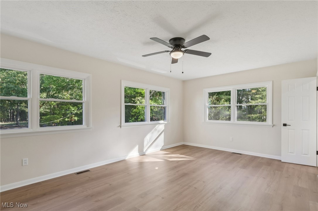 50963 Becker Road Oberlin, OH 44074 - Photo 23 of 37 Empty room with light wood-style flooring, a ceiling fan, and a textured ceiling