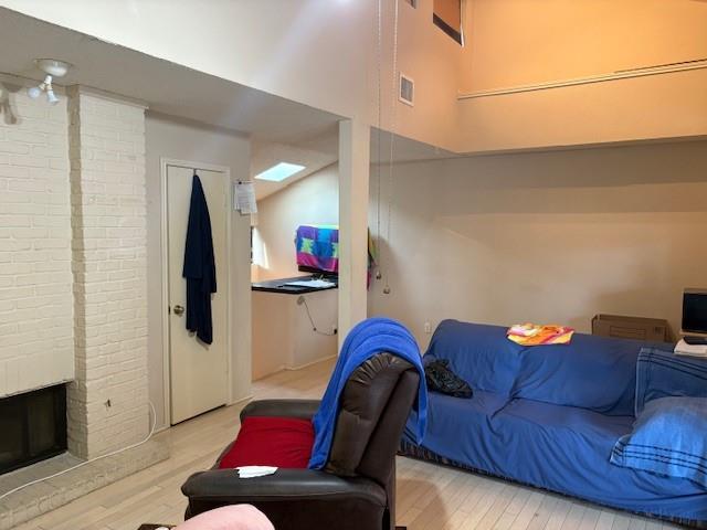 17490 Meandering Way, Unit 505 Dallas, TX 75252 - Photo 3 of 16 Living area featuring hardwood / wood-style flooring and a brick fireplace