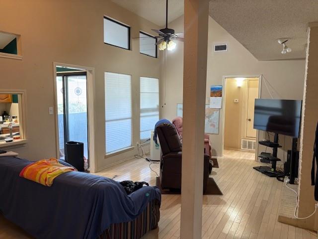 17490 Meandering Way, Unit 505 Dallas, TX 75252 - Photo 5 of 16 Living area with high vaulted ceiling, light wood-style floors, ceiling fan, and a textured ceiling