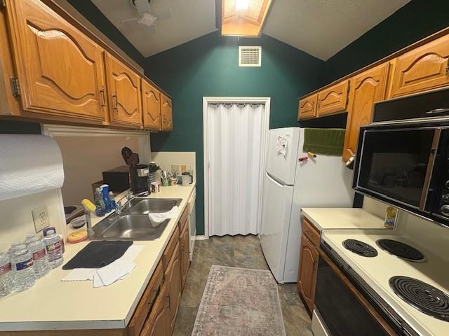 17490 Meandering Way, Unit 505 Dallas, TX 75252 - Photo 7 of 16 Kitchen with light countertops, electric stove, stone finish flooring, vaulted ceiling, and brown cabinets