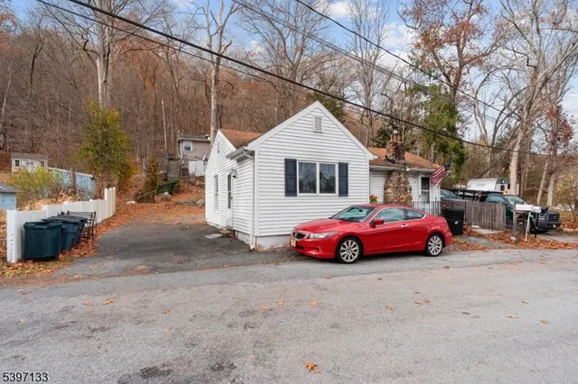 a backyard of a house with cars parked on road