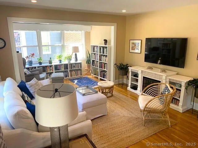 a living room with furniture a flat screen tv and a floor to ceiling window