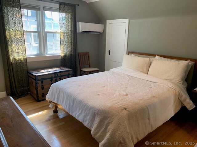 345 Courtland Avenue Bridgeport, CT 06605 - Photo 22 of 38 a bedroom with a bed and wooden floor