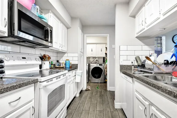 a kitchen with a sink a stove and cabinets