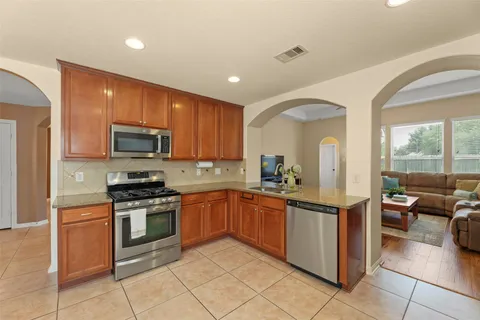 a kitchen with stainless steel appliances granite countertop a sink and cabinets