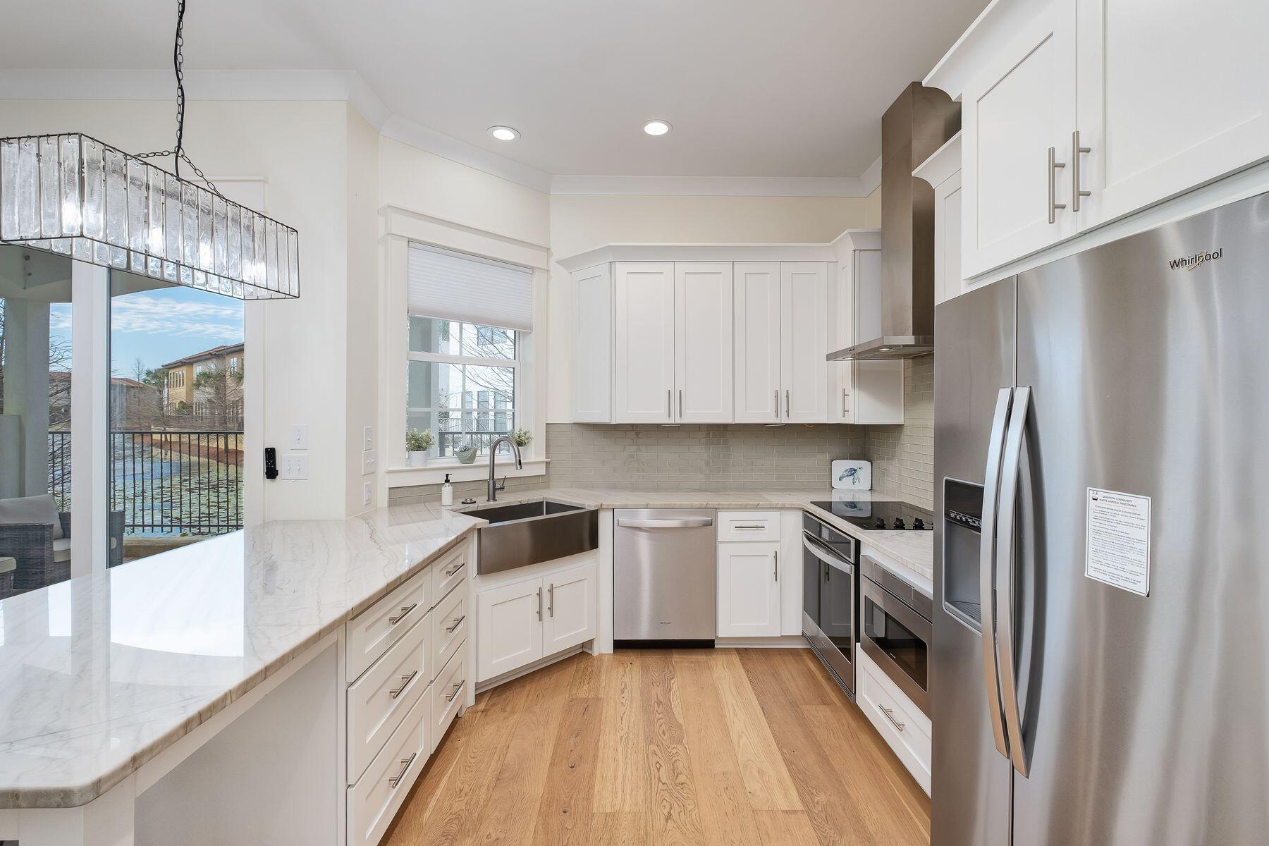 1979 Baytowne Loop Miramar Beach, FL 32550 - Photo 3 of 35 a kitchen with white cabinets and stainless steel appliances