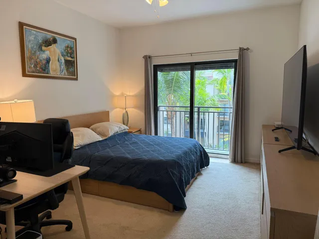 a bedroom with a bed window and a flat screen tv
