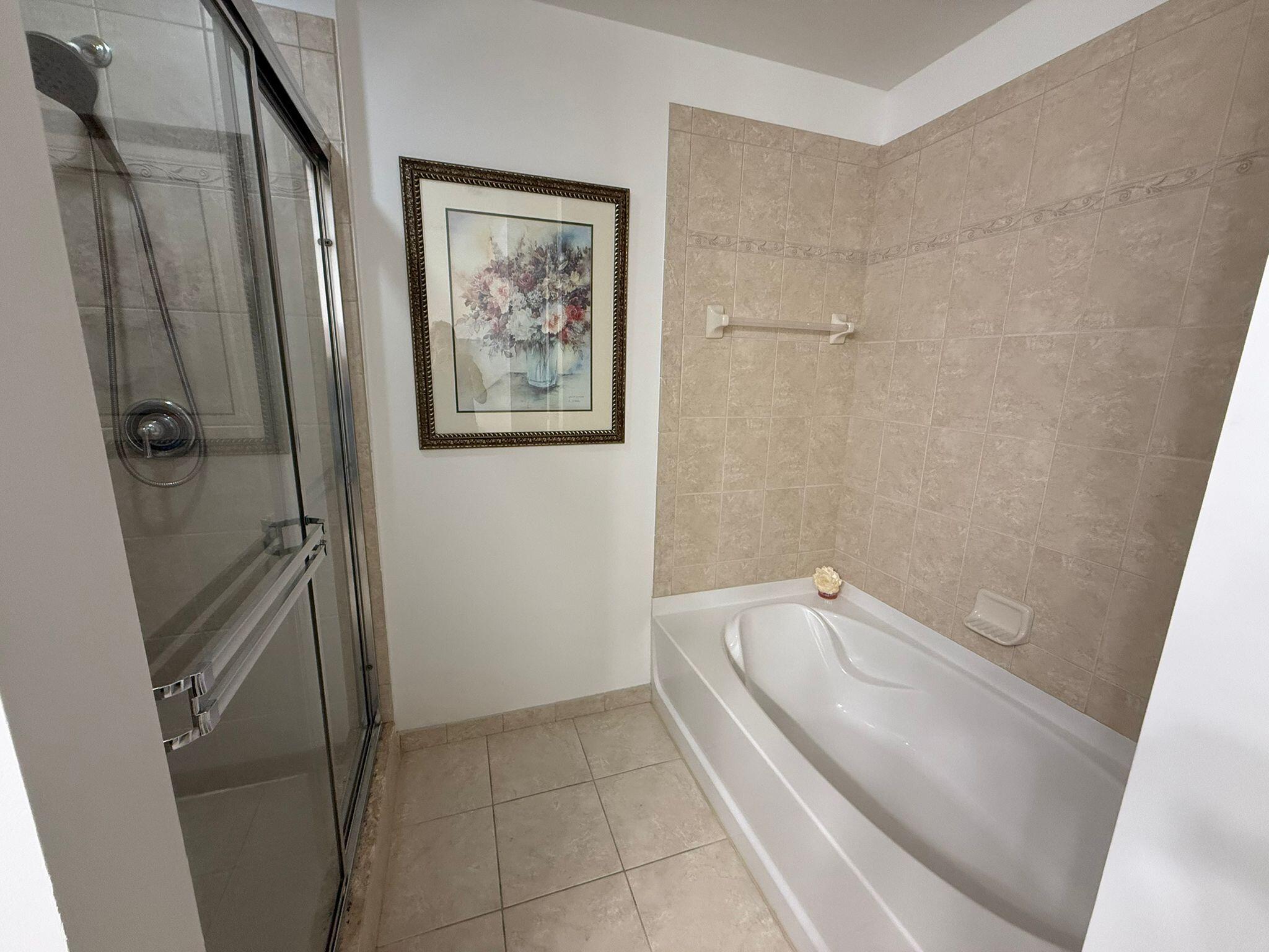 4905 Midtown Lane, Unit 2405 Palm Beach Gardens, FL 33418 - Photo 13 of 28 a bathroom with a tub and shower