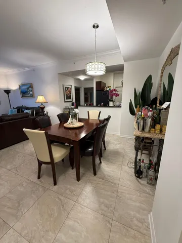 a dining room with wooden floor a chandelier a wooden table and chairs
