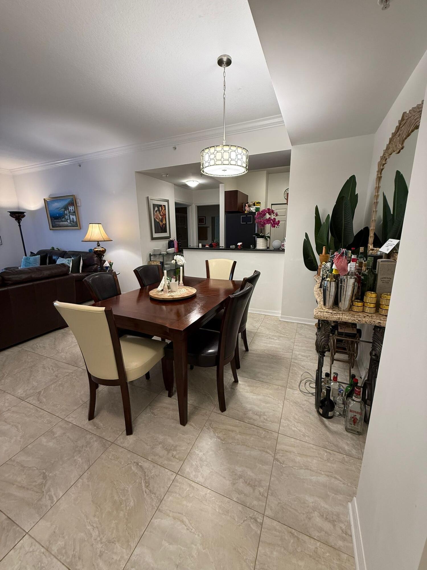 4905 Midtown Lane, Unit 2405 Palm Beach Gardens, FL 33418 - Photo 5 of 28 a dining room with wooden floor a chandelier a wooden table and chairs