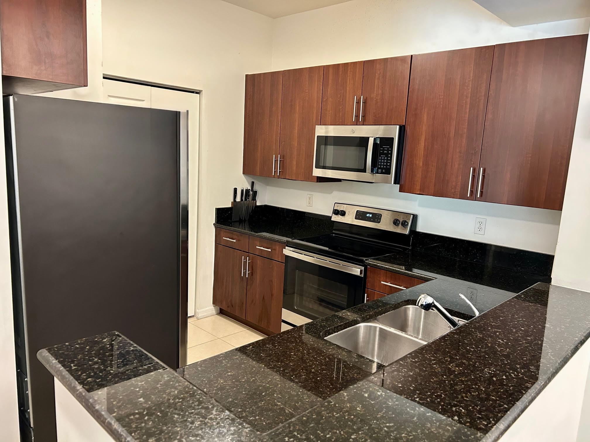 4905 Midtown Lane, Unit 2405 Palm Beach Gardens, FL 33418 - Photo 6 of 28 a kitchen with a stove and a microwave