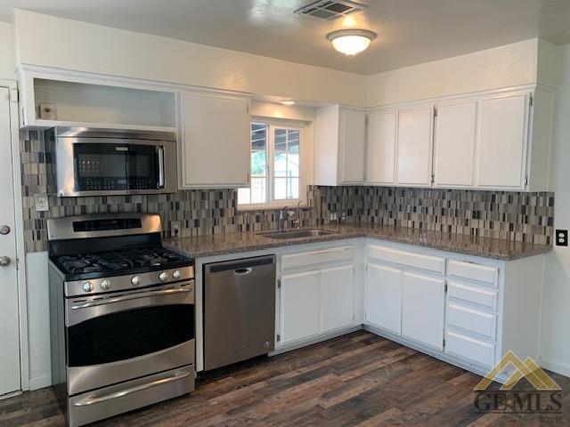 Undisclosed Address Bakersfield, CA 93304 - Photo 5 of 32 a kitchen with granite countertop a sink and a stove top oven