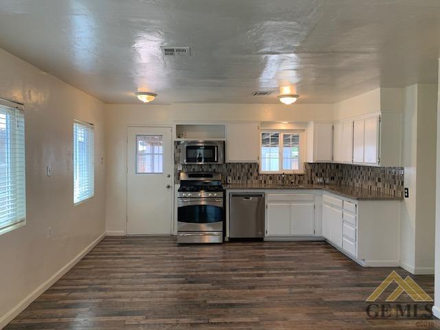Undisclosed Address Bakersfield, CA 93304 - Photo 6 of 32 a kitchen with stainless steel appliances kitchen island granite countertop a stove a sink and a refrigerator