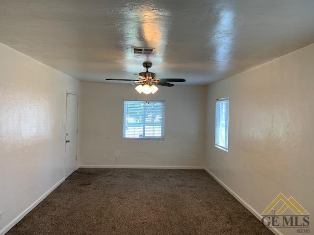 Undisclosed Address Bakersfield, CA 93304 - Photo 7 of 32 en empty room with windows and chandelier fan