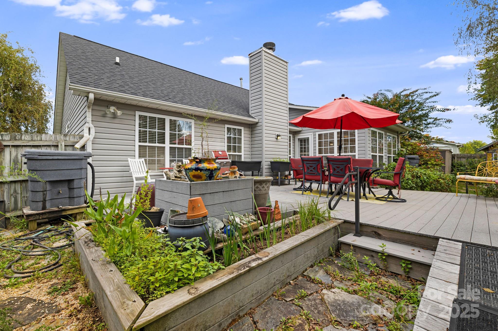 107 South Sunberry Trail Fletcher, NC 28732 - Photo 28 of 30 a view of a patio with table and chairs potted plants with wooden floor and fence