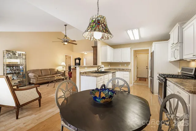 a view of a dining room with furniture a kitchen and chandelier