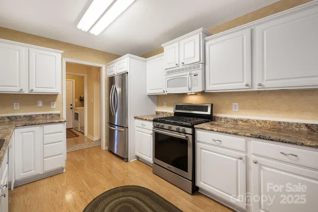 a kitchen with granite countertop a sink stove and refrigerator