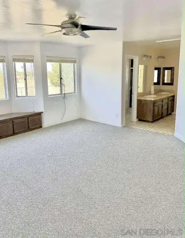 an empty room with windows and cabinet