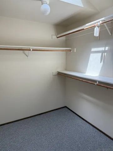 en empty room with windows and chandelier fan