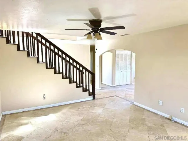 a view of a hallway with a chandelier fan and windows