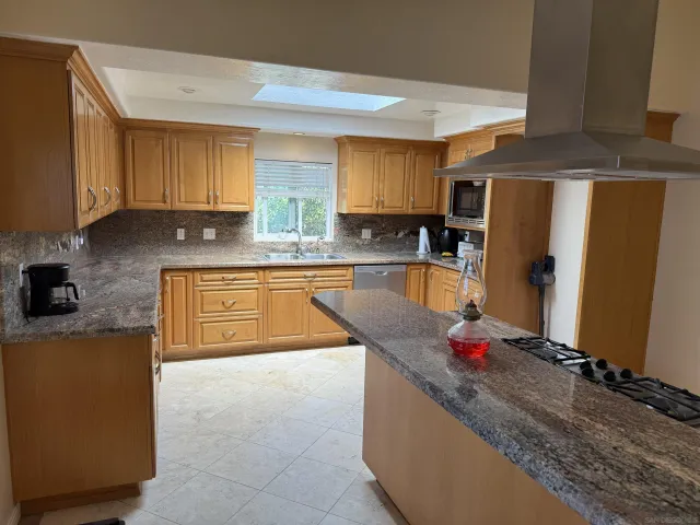 a kitchen with granite countertop a sink stove and refrigerator