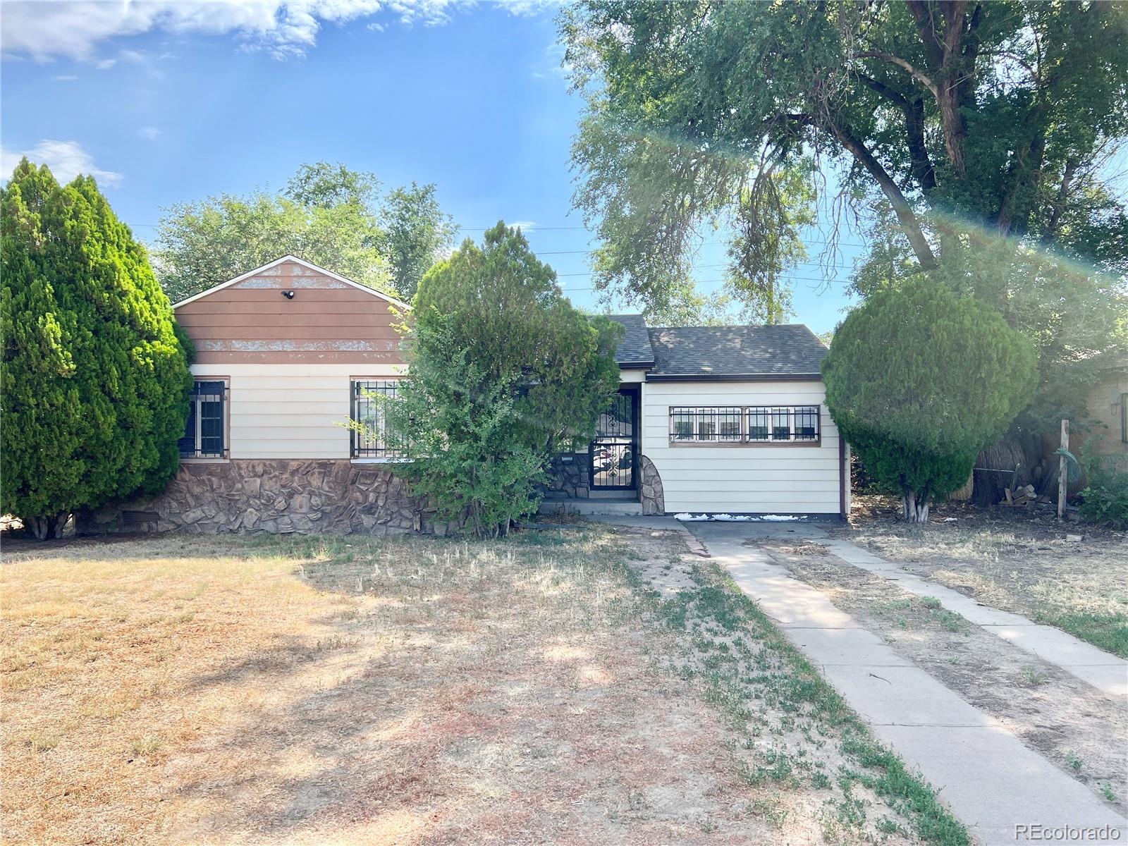 a view of a house with a yard and a large tree