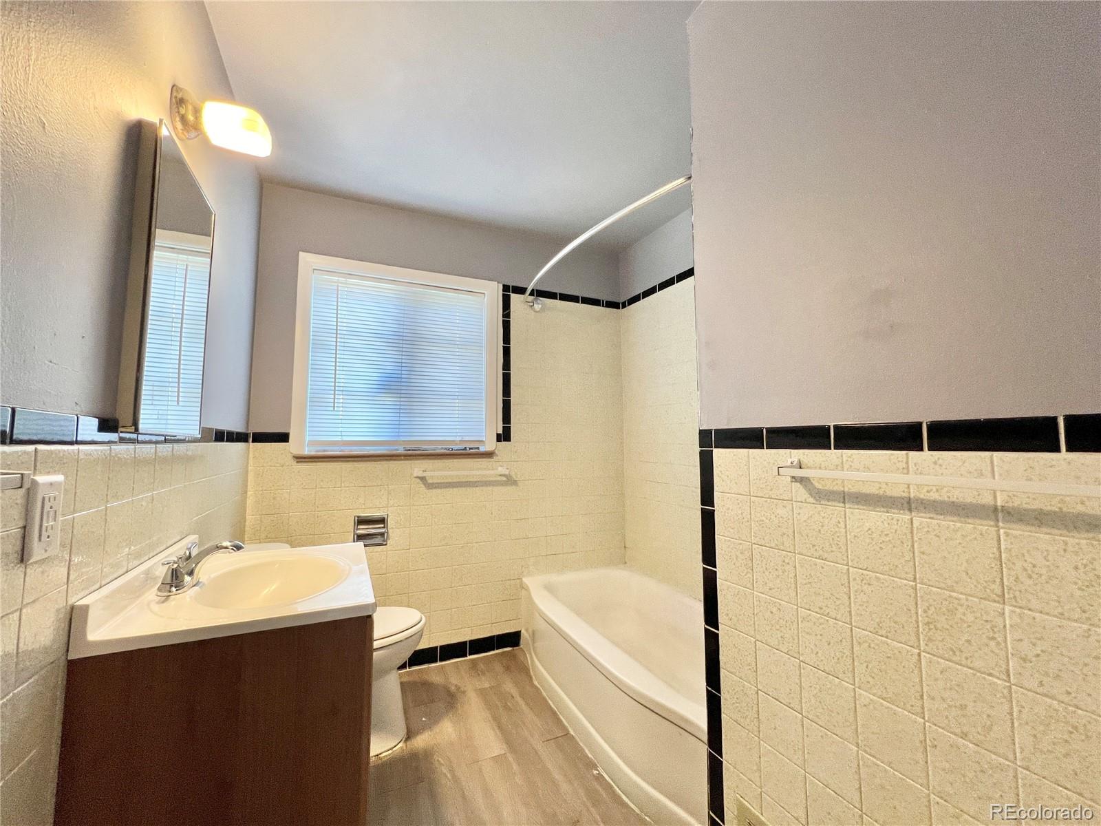 3580 Oneida Street Denver, CO 80207 - Photo 11 of 13 a bathroom with a sink mirror toilet and bathtub