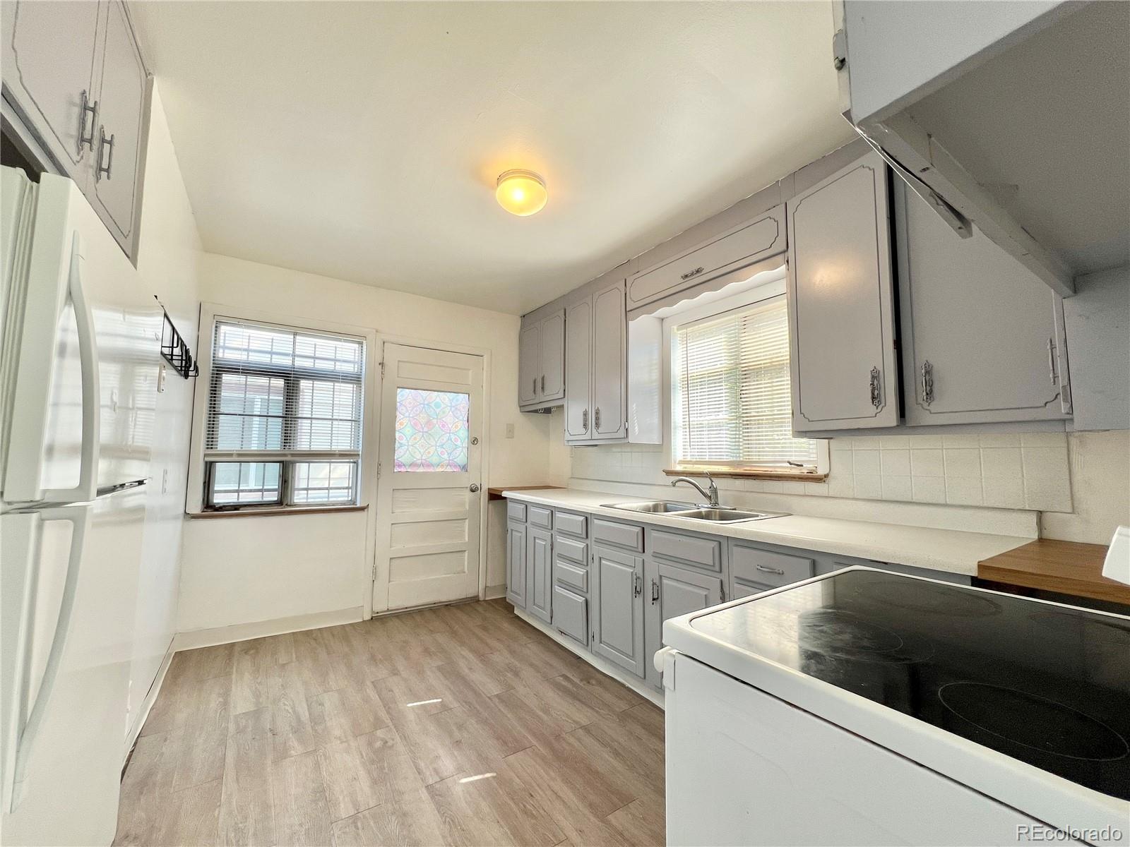 3580 Oneida Street Denver, CO 80207 - Photo 2 of 13 a kitchen with a sink stove and cabinets