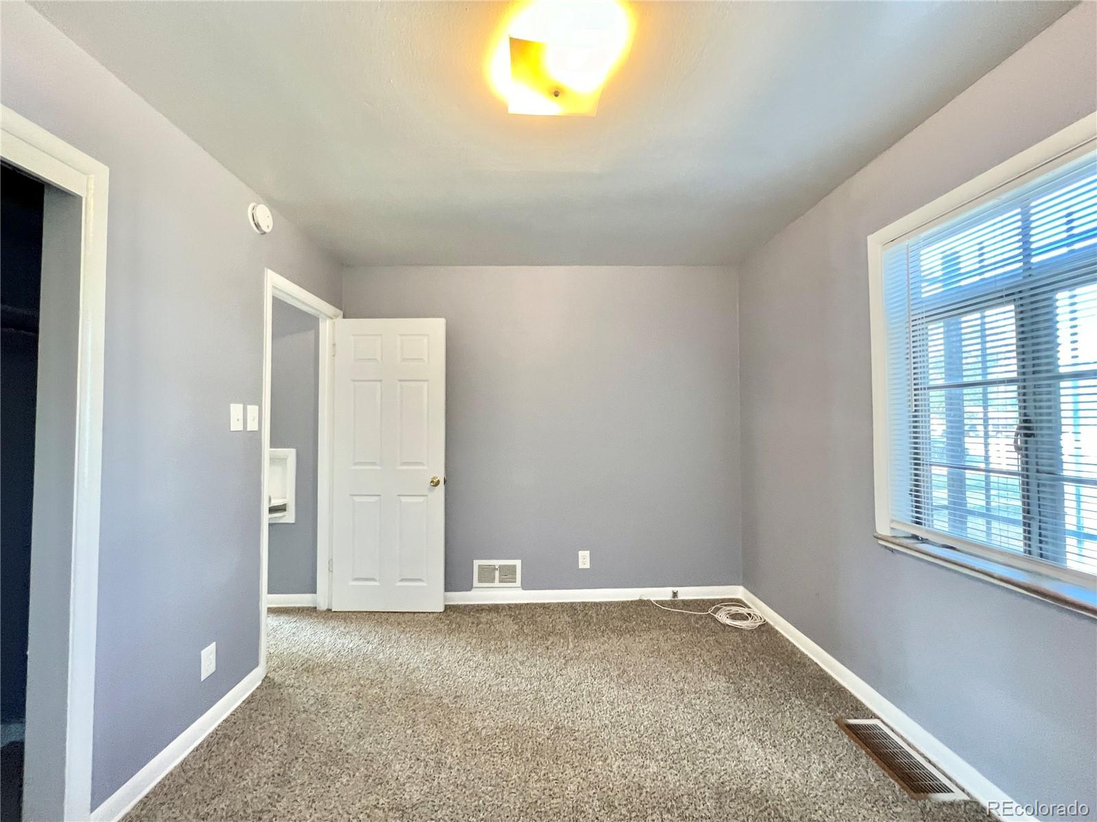 3580 Oneida Street Denver, CO 80207 - Photo 9 of 13 a view of an empty room with a window