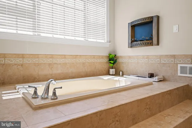 a bathroom with a granite countertop sink and a bathtub