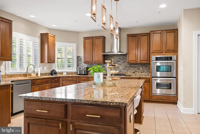 a kitchen with kitchen island granite countertop a stove a sink and a refrigerator