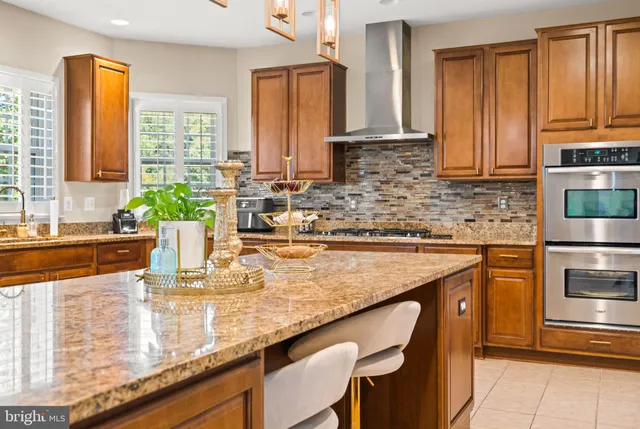 a kitchen with stainless steel appliances granite countertop a sink a stove and a refrigerator