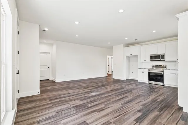 a view of kitchen a refrigerator and a stove top oven